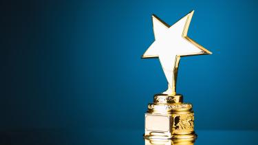 A gold trophy with a star topper on a blue background