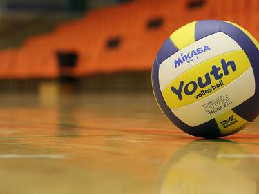 blue and yellow volleyball on a gym floor