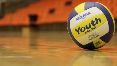 blue and yellow volleyball on a gym floor