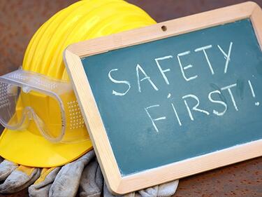 Picture of a hard hat with chalk board reading Safety First