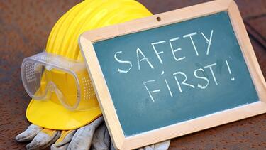Picture of a hard hat with chalk board reading Safety First