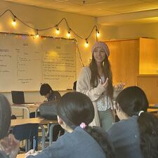 Picture of teacher speaking in front of classroom.