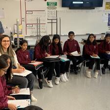 Students sitting in a semi-circle listening to a presentation