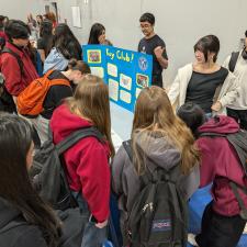 Gym filled with students who are checking out information tables about clubs at the school