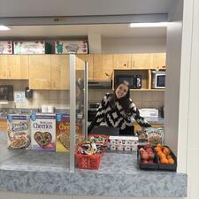 Youth Care Worker serving breakfast to students